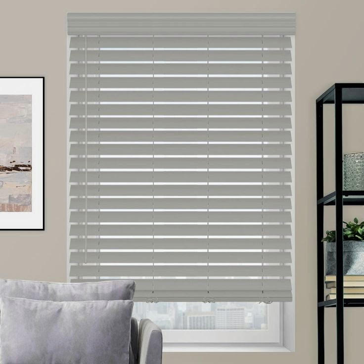 Gray faux wood blinds in a room with framed art and shelving
