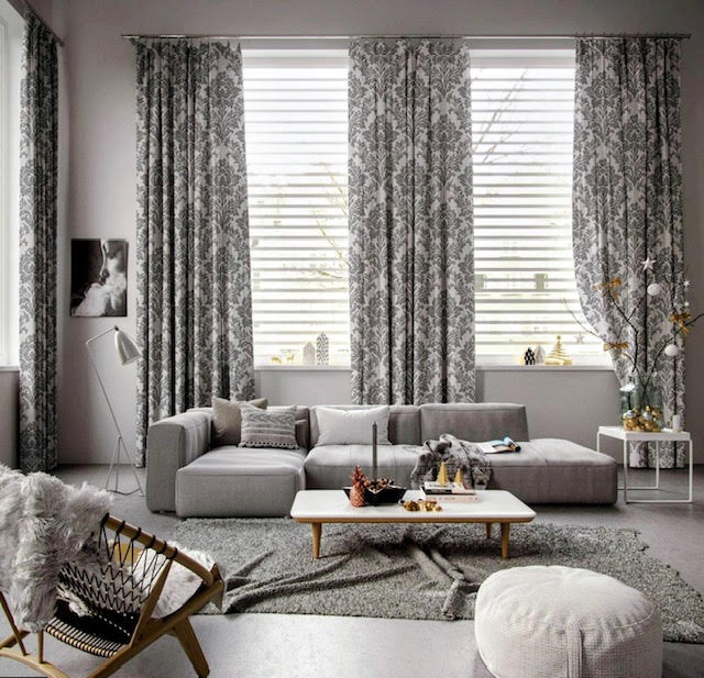 Gray damask-pattern floor-length drapes framing three living room windows