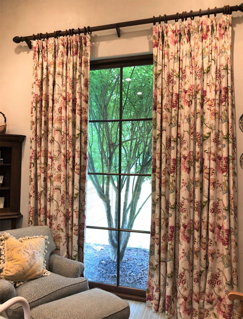 Floral pinch-pleat drapes on a wooden rod over a garden door