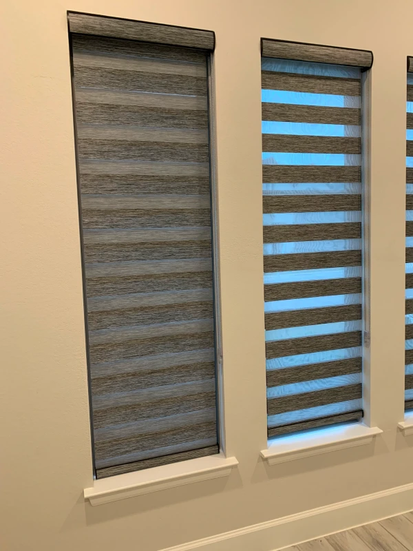 Dual-layer zebra shades in a wood-tone weave on three windows