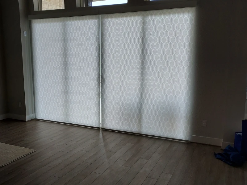 Patterned roller shades covering a large sliding glass door