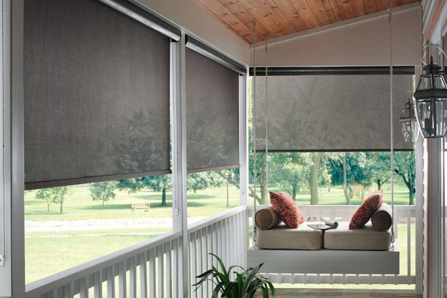 Bronze roller shades on a covered Texas porch with a daybed